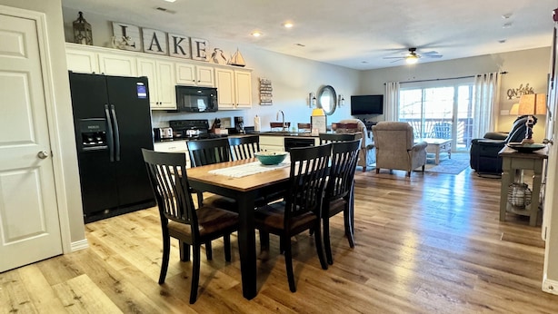 A spacious kitchen with a dining area, wooden flooring, and a ceiling fan. - 3 BR, 2 Bath Condo at Vickery Resort &  Table Rock Lake with Dock Access (Hollister)