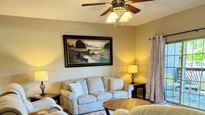A living room with a sofa, two armchairs, a coffee table, a ceiling fan, a painting, and a view through a window. - 3 BR 2 Bath Vickery Resort Walk In Condo, on Table Rock Lake with Dock Access (Hollister)