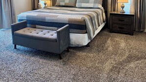 A bedroom with a bed, a bench, a nightstand, a ceiling fan, and a window with curtains. - 3 BR 2 Bath Vickery Resort Walk In Condo, on Table Rock Lake with Dock Access (Hollister)