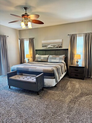 A bedroom with a bed, a bench, a nightstand, a ceiling fan, and a window with curtains. - 3 BR, 2 Bath Vickery Resort Condo, on Table Rock Lake with Dock Access (Hollister)