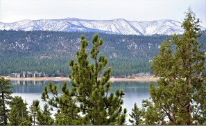 Un lac, avec une chaîne de montagnes en arrière-plan et une rangée de bâtiments le long de la rive.