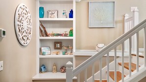 A staircase with white railings and a beige wall. - Outer Banks Bliss: 3-bedroom Cottage in Golf Community, Beach Club Access (Nags Head)