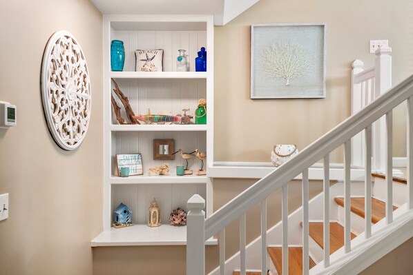 Un escalier avec des rampes blanches et un mur de couleur beige.