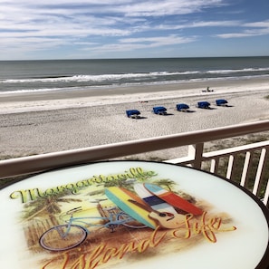 Une vue sur la plage avec une table de patio décorée dans le style « Margaritaville ».