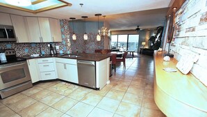 Una cocina moderna con una isla central, electrodomésticos de acero inoxidable y un salpicadero con diseño.