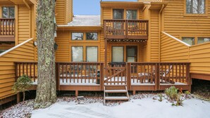 A two-story wooden building with a balcony and a staircase leading to the upper level.