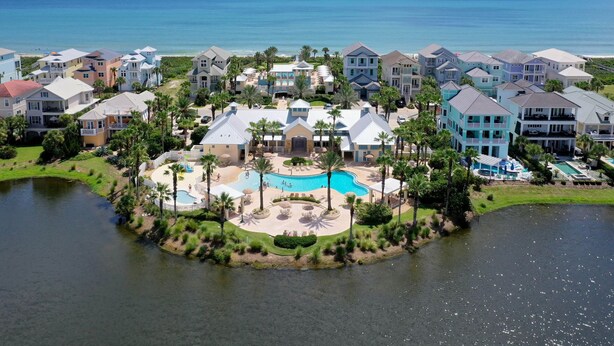 A coastal resort with multiple buildings, a central swimming pool, and a view of the ocean. - Cinnamon Beach Unit 323- Just a few steps to the Sun and Sand! (Palm Coast)