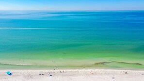 Une plage à l’eau turquoise et limpide, bordée d’un rivage sablonneux.