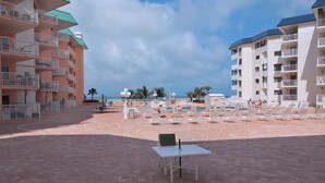 Un complexe hôtelier doté d’une piscine, de chaises longues et offrant une vue sur l’océan.