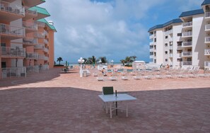 Un resort con zona de piscina, sillones de descanso y vistas al océano.