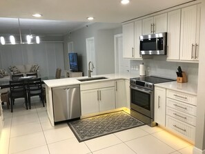 Enjoy cooking in this well-equipped kitchen with a dishwasher, oven, microwave, and dining area.
