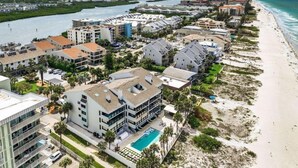 A coastal hotel with multiple buildings, a swimming pool, and a beach. - Quiet Waters Condominium 5B (Indian Shores)