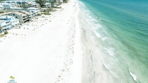 A beachside resort with multiple buildings, a sandy beach, and ocean views. - Quiet Waters Condominium 5B (Indian Shores)