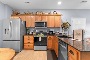 Una cocina moderna con armarios de madera, electrodomésticos de acero inoxidable y encimera de granito.