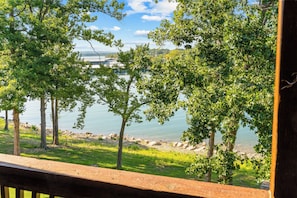 Une vue sur le lac, avec des arbres et une terrasse en bois.