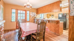Una cocina con armarios de madera, una isla central y una mesa de comedor con sillas.