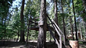 En enkel träkonstruktion i ett skogsområde, troligen en utkiksplats eller observationspunkt.