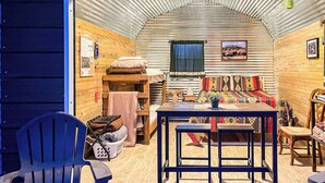 A cozy interior with a wooden bench, a table, and a window with curtains. - W-W: Pavilion and Glamping Village (Monticello)