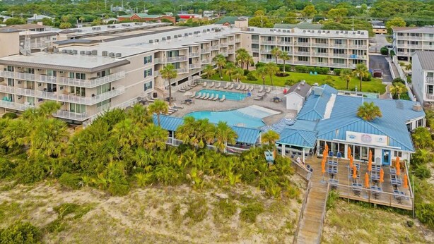 Ein Resort mit mehreren Gebäuden, einem Poolbereich und einem Strand.