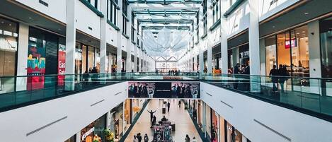 A multi-level shopping mall with glass railings and a central atrium.