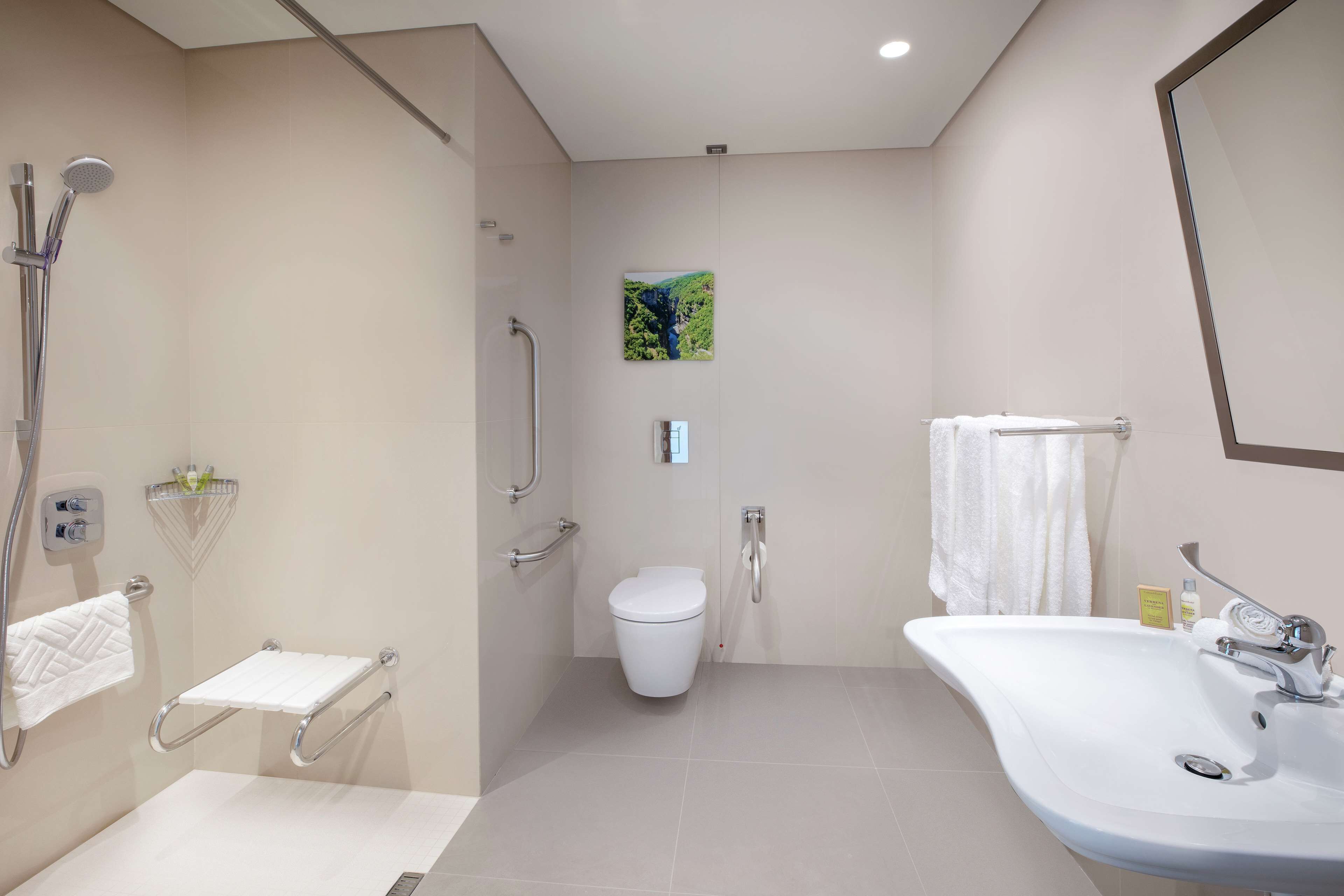 A modern bathroom with a shower, toilet, and sink.