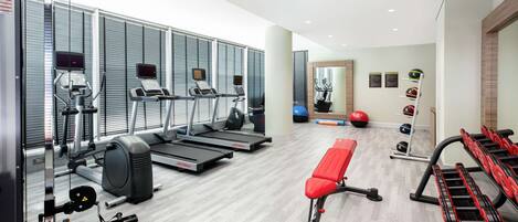 A gym with treadmills, a bench, and various exercise equipment.