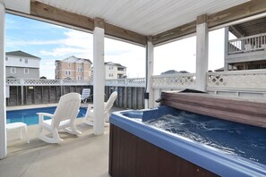 Relax by the pool in a serene outdoor space with a hot tub and Adirondack chairs.