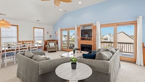 A spacious living room with a large sofa set, a round coffee table, and a fireplace.