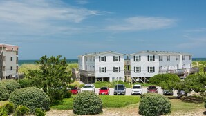 Un quartier résidentiel situé en bord de mer, avec des maisons à deux étages, un parking et une vue sur l’océan.