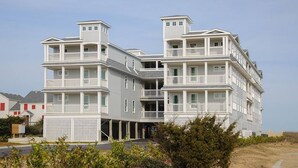 A multi-story building with balconies and a covered entrance. - Star of the Sea: Oceanfront Condo, Shared Pool (Kill Devil Hills)
