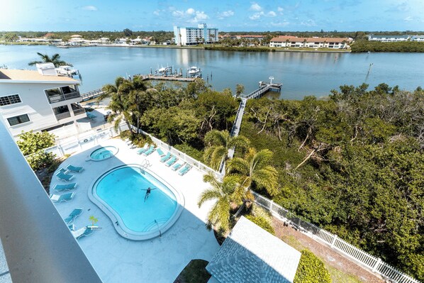 A hotel with a swimming pool, a dock, and a view of a lake.