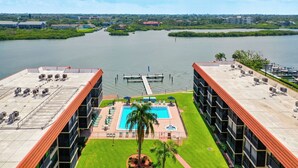 A rooftop pool with a view of a lake and dock.