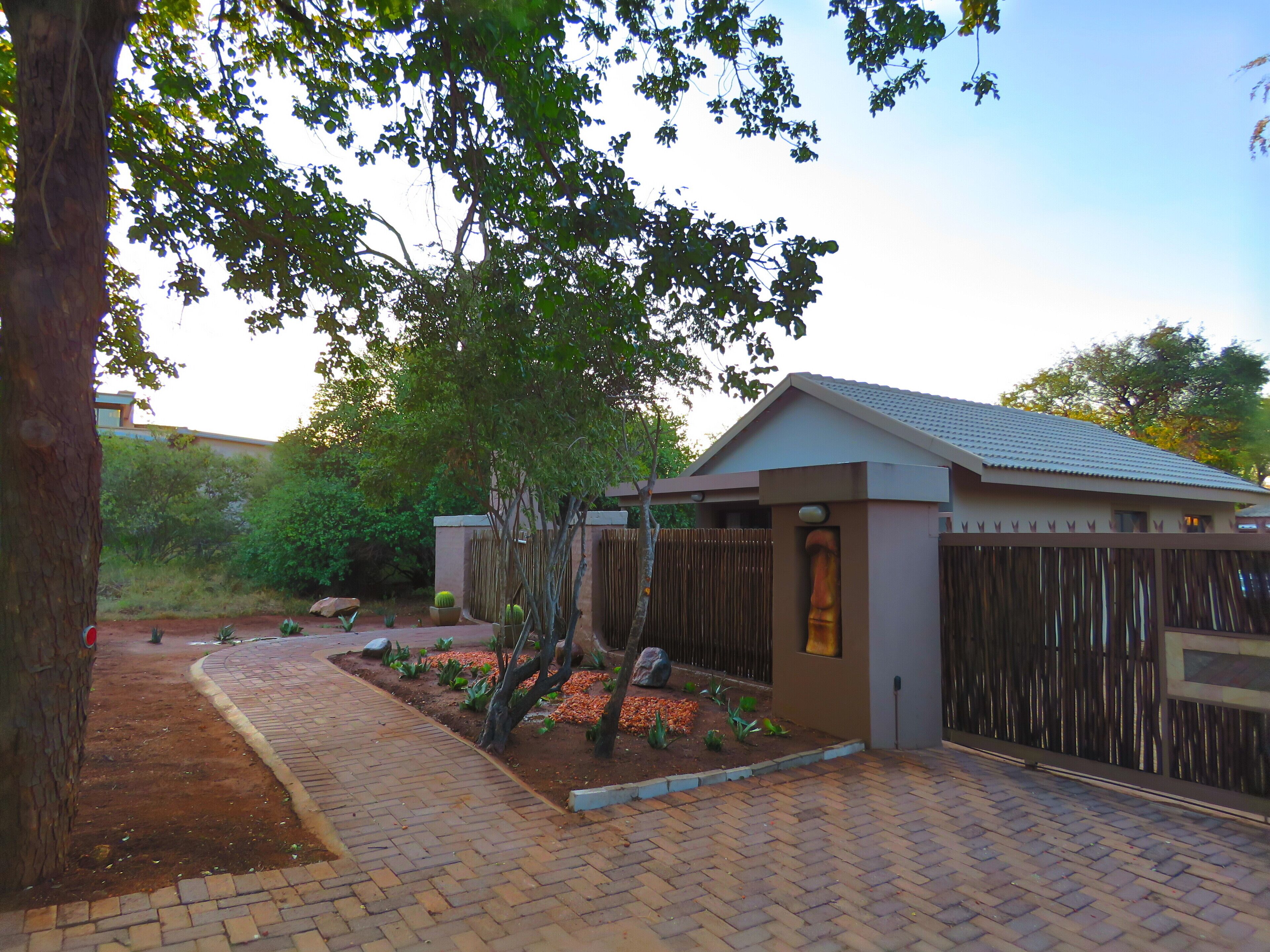 A modern building with a brick pathway leading to a gated entrance.