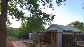 A modern building with a brick pathway leading to a gated entrance.