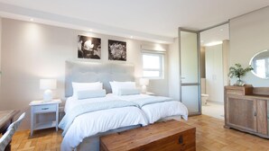 A modern bedroom with a large bed, bedside tables with lamps, a wooden chest, and a wardrobe. - 109 on Dorp (Stellenbosch)