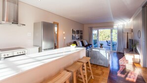 A modern kitchen with a central island, bar stools, and a dining area with a view. - 109 on Dorp (Stellenbosch)