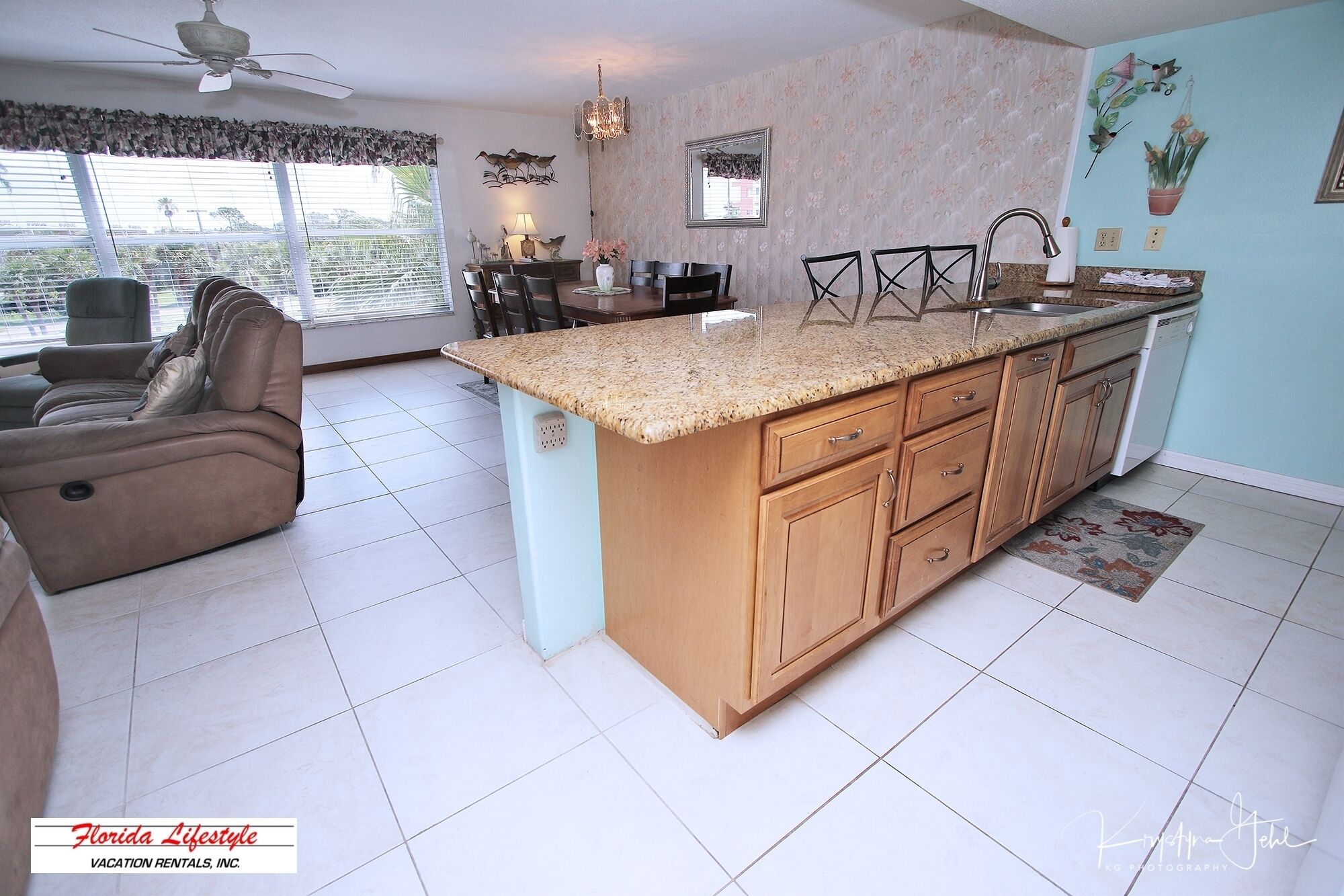 A spacious living area with a large island kitchen, a dining table, and a sofa.