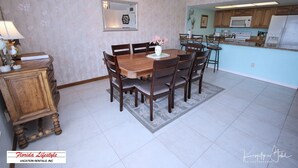 A dining area with a wooden table and chairs, a small cabinet, and a mirror on the wall.