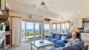 Ein Wohnzimmer mit einer Couch, einem Couchtisch und Blick auf den Ozean.