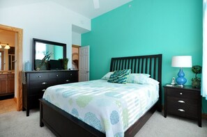 A bedroom with a bed, dresser, nightstand, and a mirror. - Surround Sound: Sound View, Shared Pool, Balcony (Nags Head)