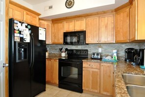 Kitchen equipped with a stove, microwave, toaster, and sink.