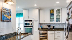 A modern kitchen with white cabinetry, granite countertops, stainless steel appliances, and a built-in oven. - Oates Bluff: Pet friendly, Beach Club Access w/ Community Pool & Tennis Courts (Nags Head)