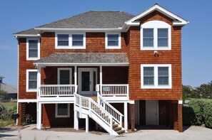 A two-story house with a front porch, a staircase, and a garage.