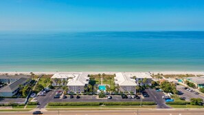 A coastal hotel with a central pool, multiple parking lots, and a beach view. - Tortugas DeMar103B-Gulf Front & Ground Level-Fabulous 2 BR unit in Belleair! (Belleair Beach)