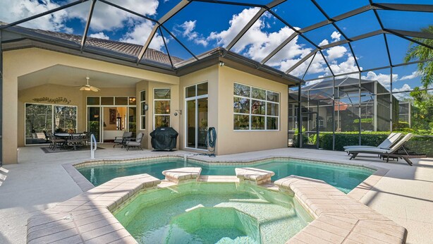 A covered swimming pool with lounge chairs, a hot tub, and a patio area with outdoor furniture. - Luxurious Mediterranean Style Home! The finest finishes - Private Heated Pool (ESTERO)