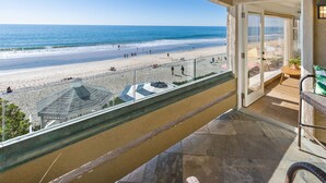 Ein Balkon mit Blick auf Strand und Meer.