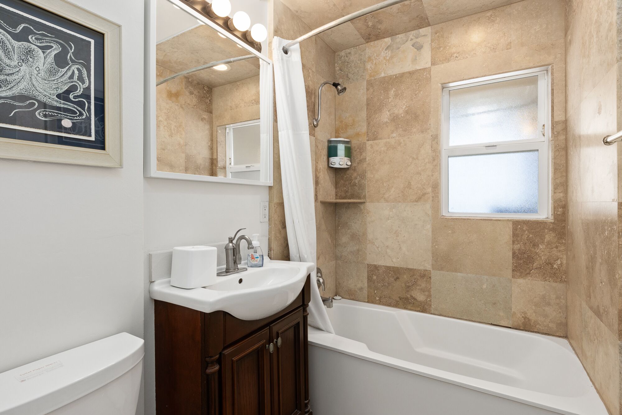 A bathroom with a bathtub, a sink, a mirror, and a shower.