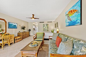A spacious living area with a dining table, sofa, and chairs.