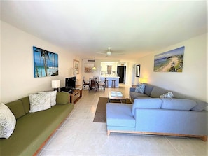 Relax in a spacious living area with a large sofa, flat-screen TV, and framed artworks.