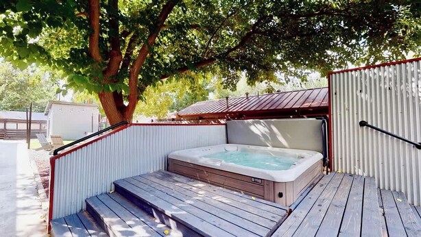 A hot tub with steps leading up to it, surrounded by a wooden deck and metal fencing. - Moab Flats - 3, Escape to Moab! Walking Distance t (Moab)